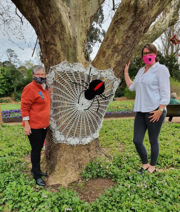 Moss Vale Evening CWA President Jennifer Bowe stands with crafter Lesley Tetley who created one of the spiders displayed in the trees. Photo: Moss Vale Evening CWA Facebook 