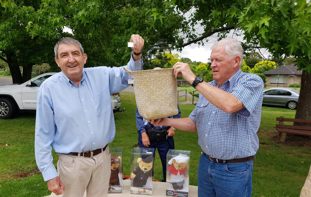 Southern Highlands Sub Branch of the National Servicemen's Association patron Duncan Gair (left) draws a winning ticket from President Robert Brown for the Christmas raffle. Picture: Suppl
