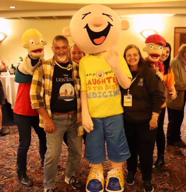 Bill and Carmel with Camp Quality's mascot Giggle (middle with yellow T-Shirt) and charity puppets Dean (far left) and Kylie (far right). Picture: Supplied 