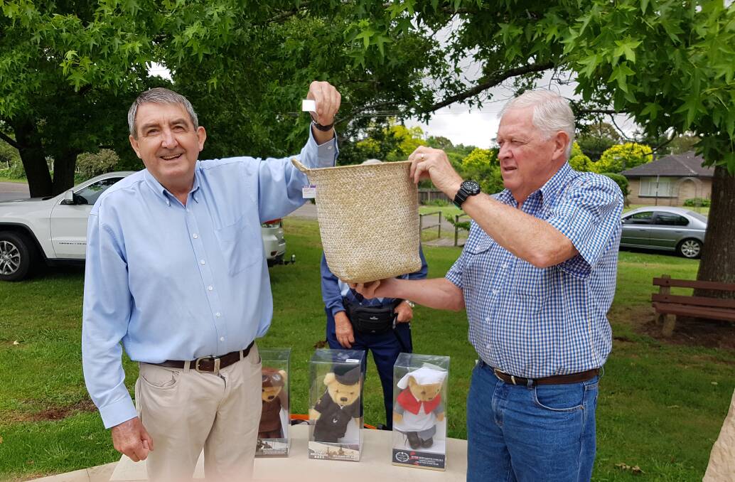 Southern Highlands Sub Branch of the National Servicemen's Association patron Duncan Gair (left) draws a winning ticket from President Robert Brown for the Christmas raffle. Picture: Suppl 