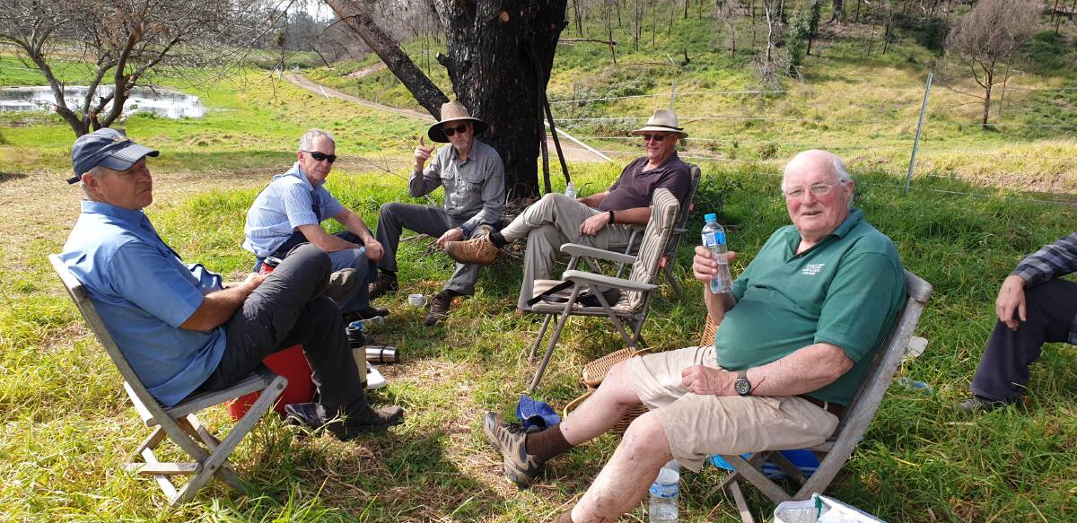 Members of the Rotary Club of Bowral-Mittagong sat and had a tea break when they built fences for areas devastated by bushfires. Photo: Supplied 