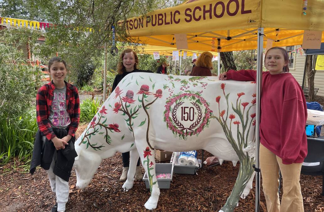 Robertson Public School students Sofia Stanley, Coral McInnes and Niah Dolan painted various Australian plants onto the cow. Picture by Briannah Devlin. 
