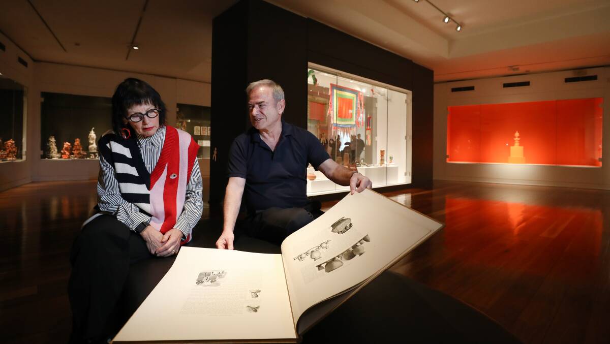 Sally Hardy from Theodore Bruce Auctioneers and Valuers with George Faddoul looking through a book at the Wollongong Art Gallery. Picture by Adam McLean