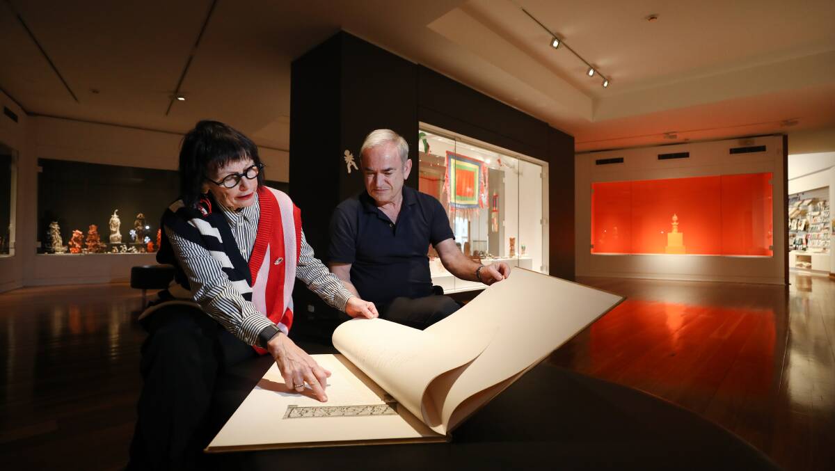 Sally Hardy from Theodore Bruce Auctioneers and Valuers with George Faddoul looking through a book at the Wollongong Art Gallery. Picture by Adam McLean