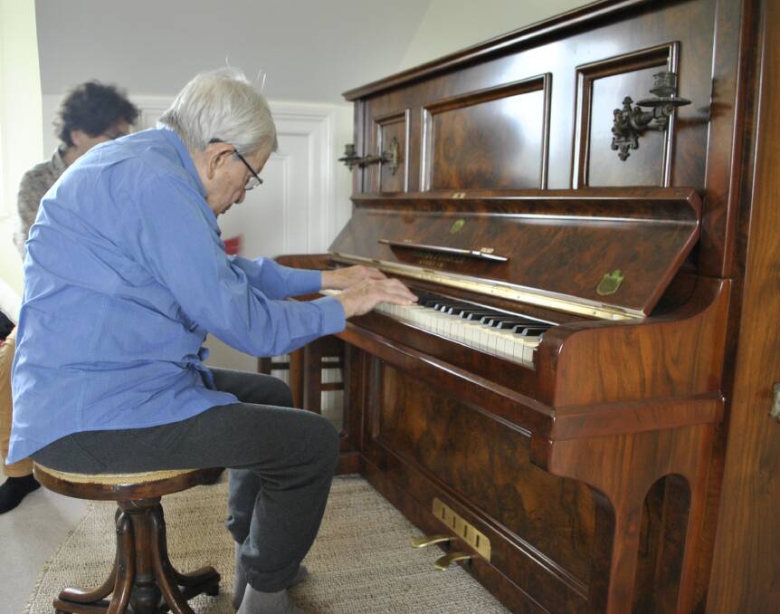 REUNITED: Surrounded by family, Jim Somerville was reunited with his childhood piano at it's new home at a farm in Medway. Photo: Charli Shield. 