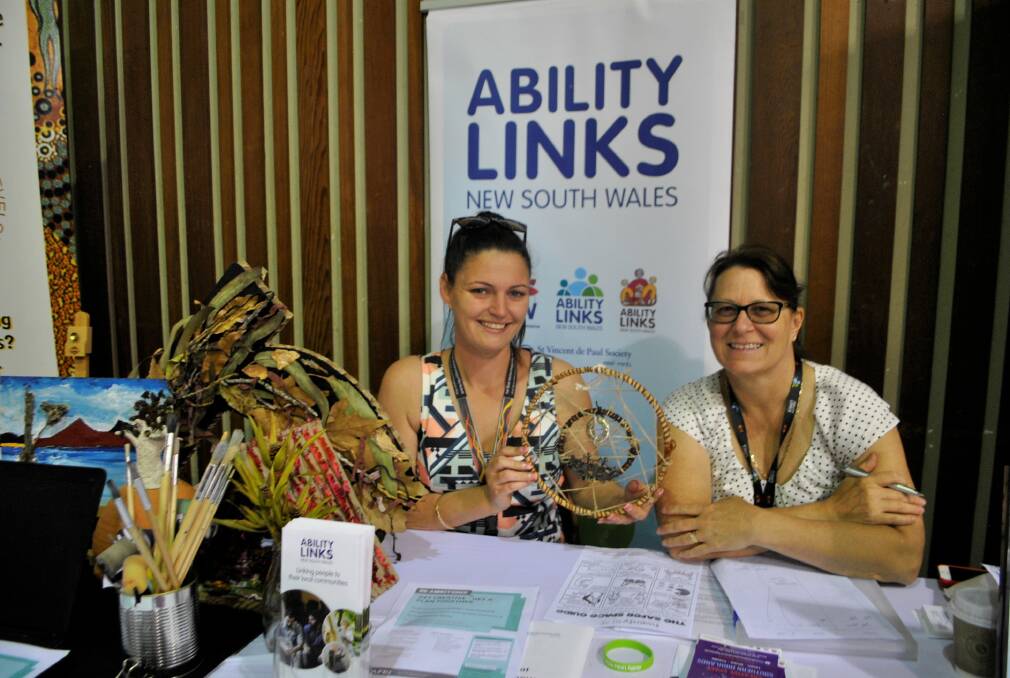 Lauren Casey and Carolyn Koch from disability support provider Ability Links, with some of the artwork on display from their inclusive art program, 'Creative Space'. Photo: Charli Shield.