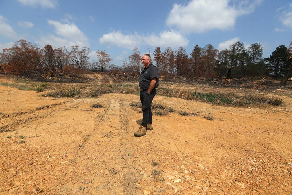 Reflective: Standing in a dry creek bed in January, Balmoral resident Mick Duggan surveys the damage to his property caused by a bushfire.