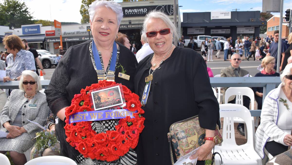 Innerwheel president Brenda Apostolatos and vice president Barbara Smith prepared to lay a wreath of knitted poppies at the Bowral Day service in 2019.