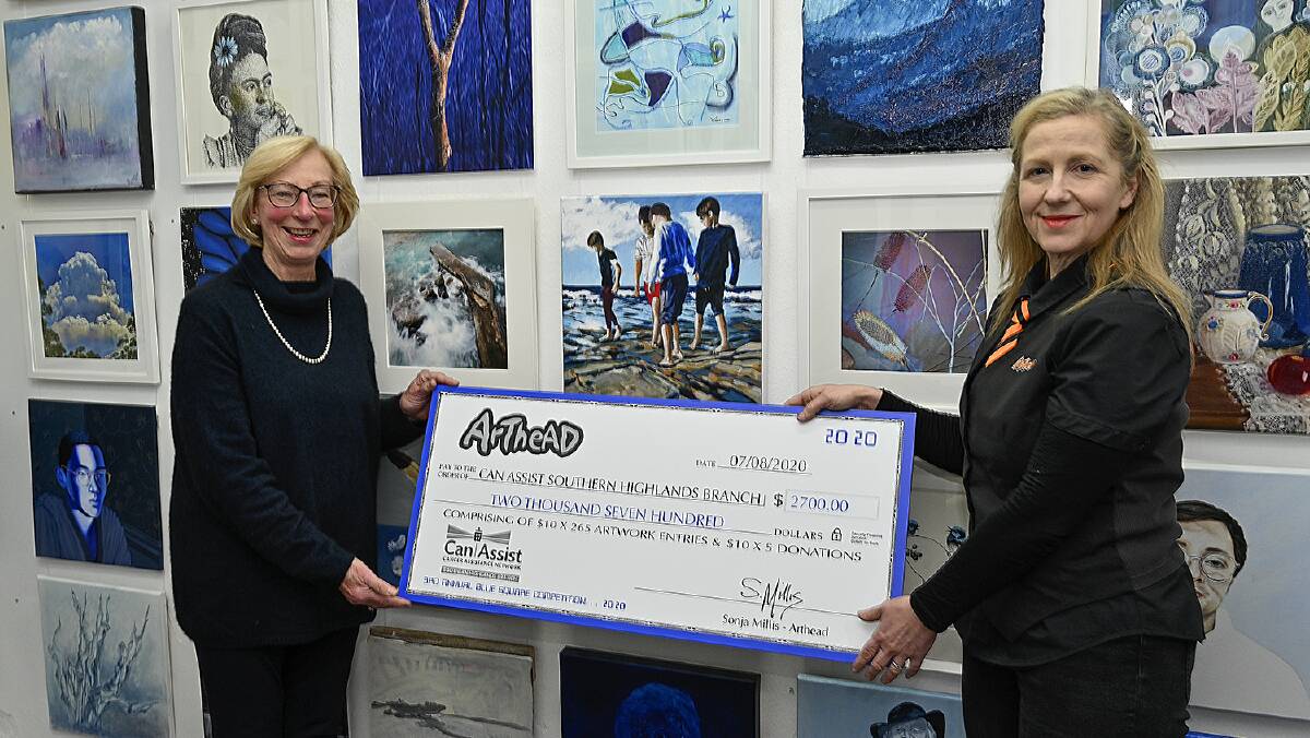 CanAssist president Jenny Harper OAM is presented with a cheque for $2700 from ArtHead owner and co-founder Sonja Millis. Photo by John Swainston