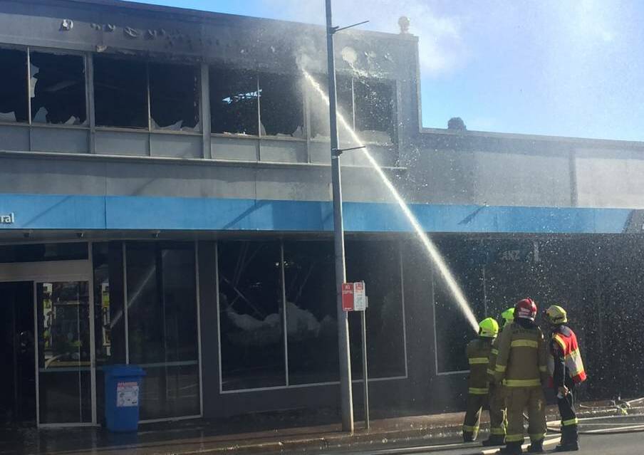 Firefighters attempting to cool hot spots in the roof of the ANZ Bank following last week's blaze. Photo: Michelle Haines Thomas