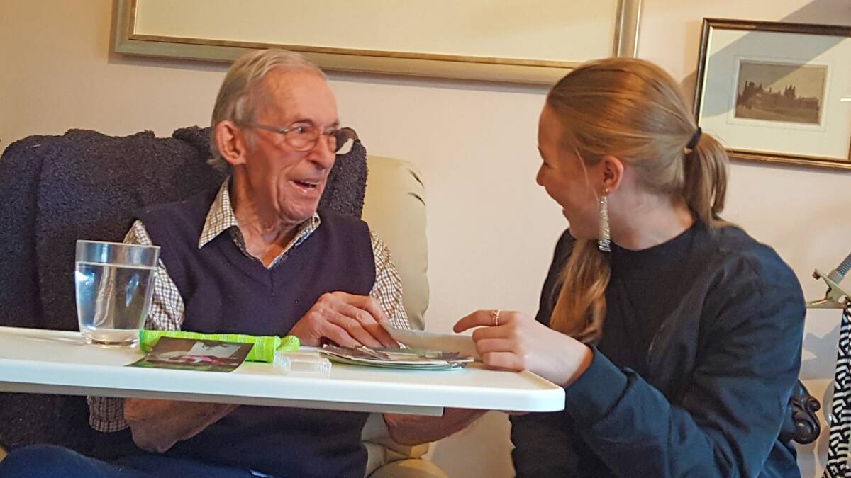 Charlie Eldridge shares photos with his granddaughter, Natalie Anderson, in October 2018. At the time he had very advanced Alzheimers and was cared for at home by a team of carers, friends and relatives who learnt how to communicate with him and keep his smile alive. Charlie died just four weeks later. Photo supplied 