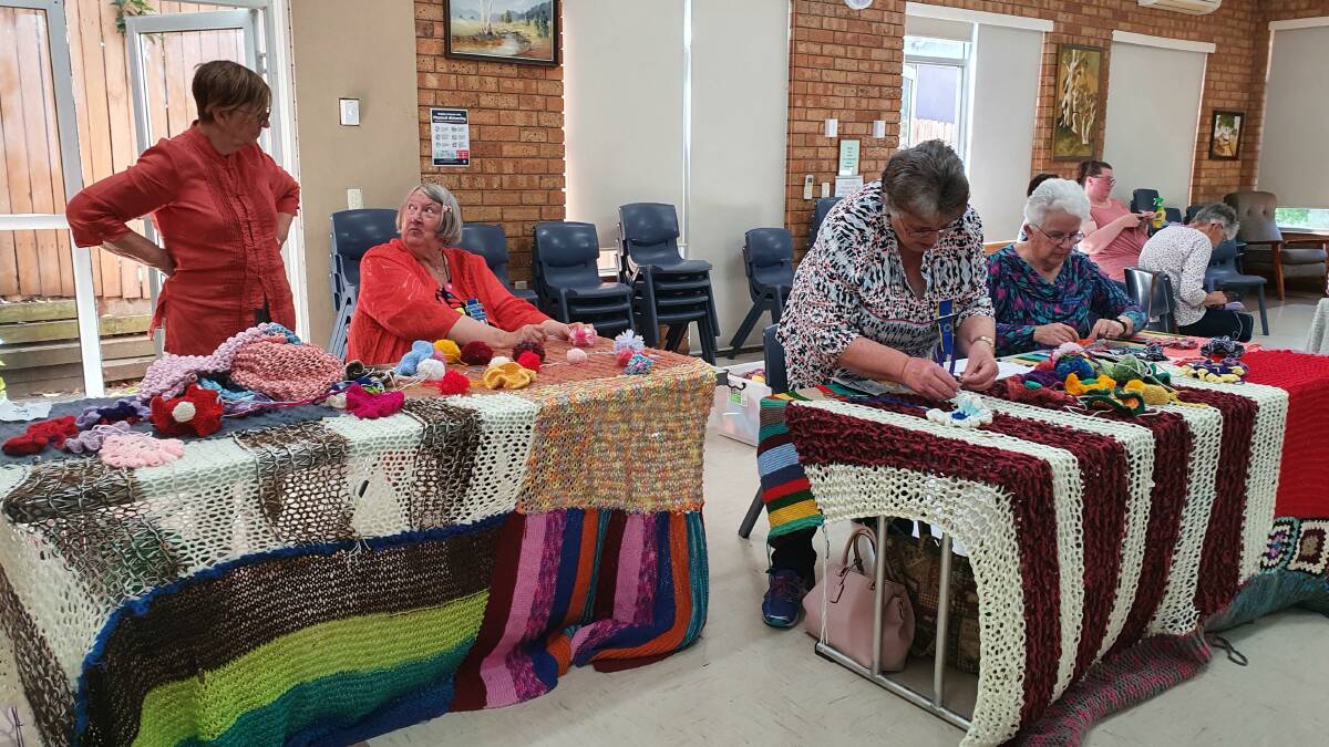Moss Vale Evening CWA branch members get busy on their yarn bombing project. Photo supplied
