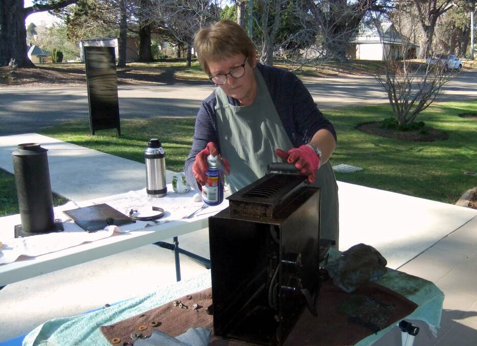 SHINING LIGHT: Maria Tomesek cleaning an old lantern-style projector at Berrima District Museum. Photo supplied