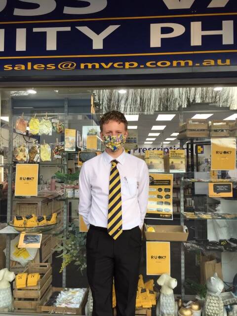 Jeremy Millward standing out the front of Moss Vale Community Pharmacy, with an R U OK display in the window. Picture: Supplied.