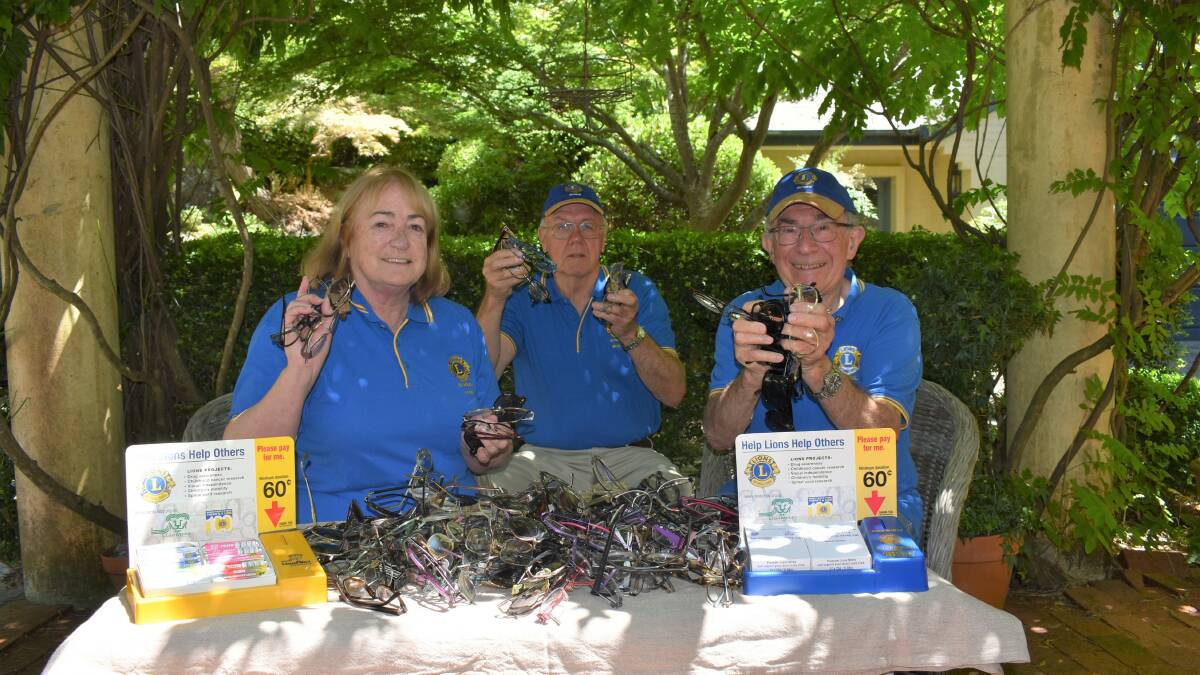 Lions members Anne Robinson, Bruce Blunden and Bill Bransom with some of the glasses they have collected and are sorting through. Photo: Lauren Strode
