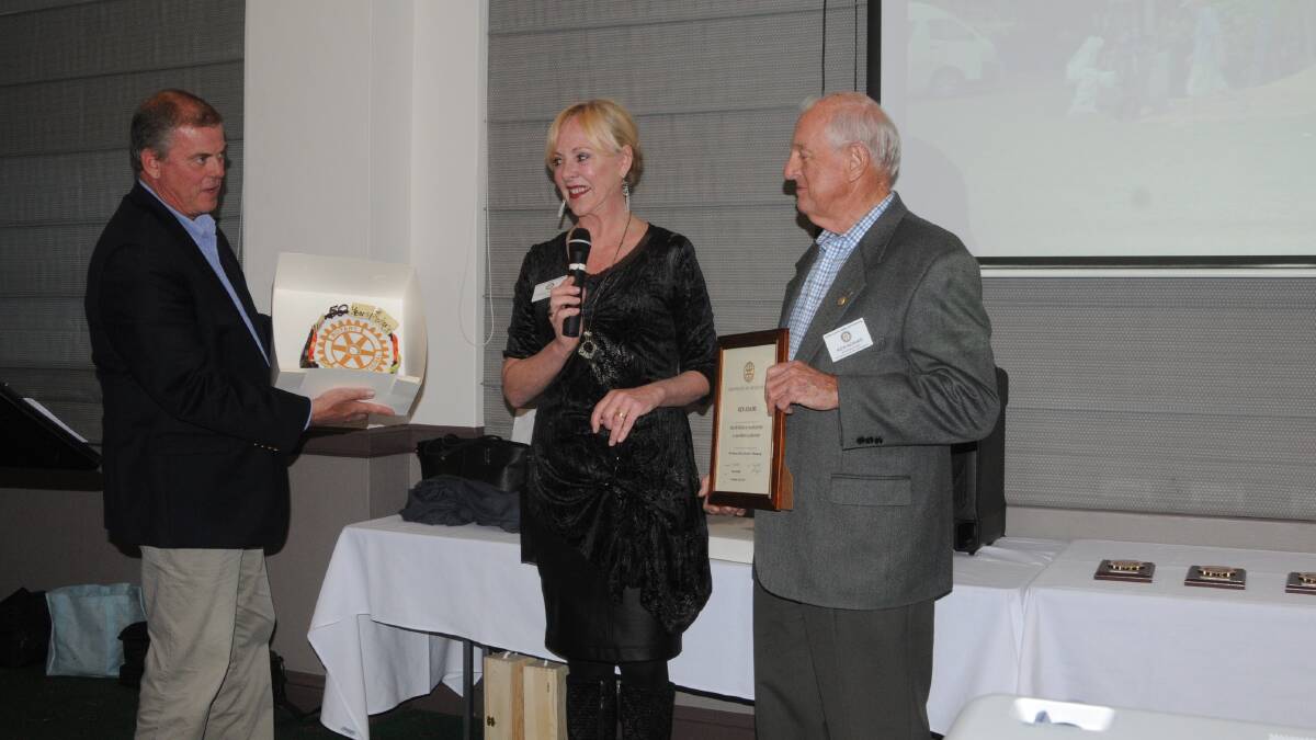 COMMUNITY SERVICE: Ken Adams was recently recognised for 50 years of service to Rotary and received an award and a cake from Simon and Linda Knight. Photo: Lauren Strode