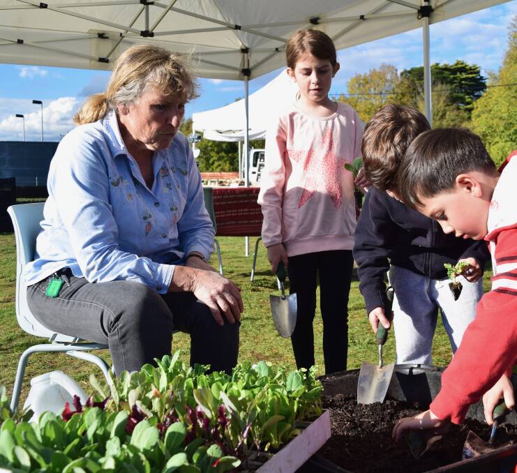 PLANT TO PLATE: Jill Cockram from Moss Vale Community Garden working with children potting up seasonal seedlings of cabbage, broccoli, cauliflower, lettuce, beetroot and leeks to take home and transplant into their own gardens. Photo: supplied