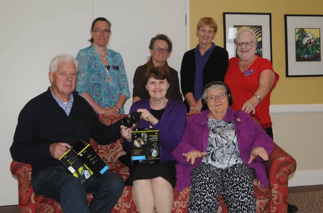 Lesley Tetly, Jan Stewart, Ingrid Van Kerval and Heather Peacock are happy to accept the iPods that Gerry Kroon hands over to Vernia Blundell as Warrigal resident Joyce Garland enjoys listening to some music. Photo: Lauren Strode