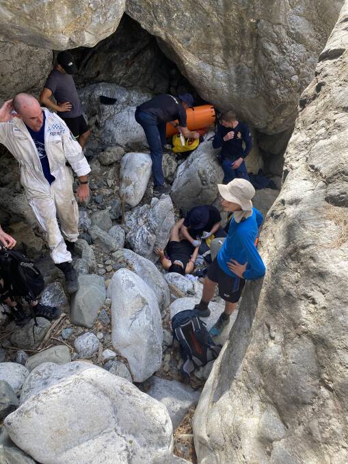 Two police officers carried a woman out of the Bungonia National Park on Saturday after she fell and became stuck between two boulders. Photo: NSW Police.