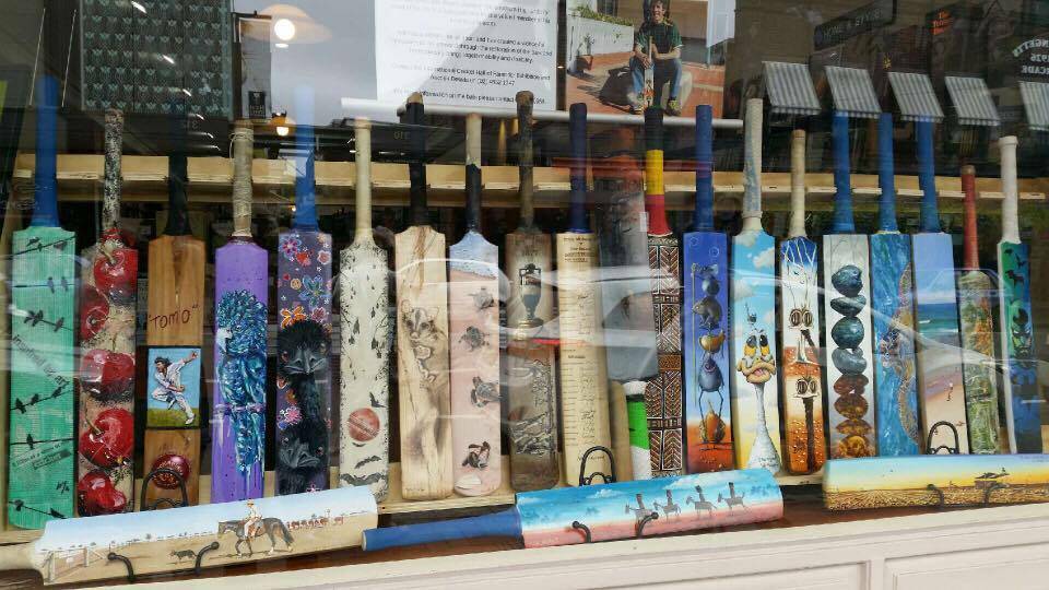 WILLO BATS: Will Clarke's restored and painted bats on display in the window at the Bookshop Bowral on Bong Bong Street. Photo: Lauren Strode. 