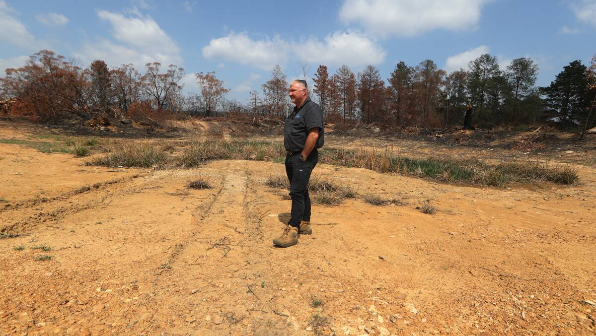 SURVIVAL AMID FLAMES: Balmoral resident Mick Duggan surveys the damage to his property in the middle of a dry creek. Photo: Robert Peet