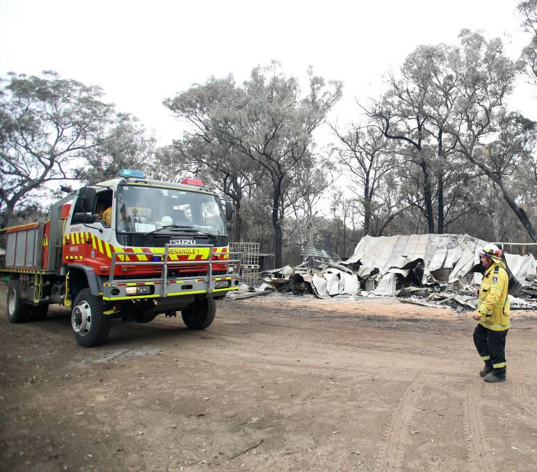 BACK TO WORK: A Menangle RFS volunteer walks to their fire truck at Bargo in December. Firefighters are expected to face tough conditions as they battle the Green Wattle Creek and Currowan fires on Saturday. Photo: Adam McLean