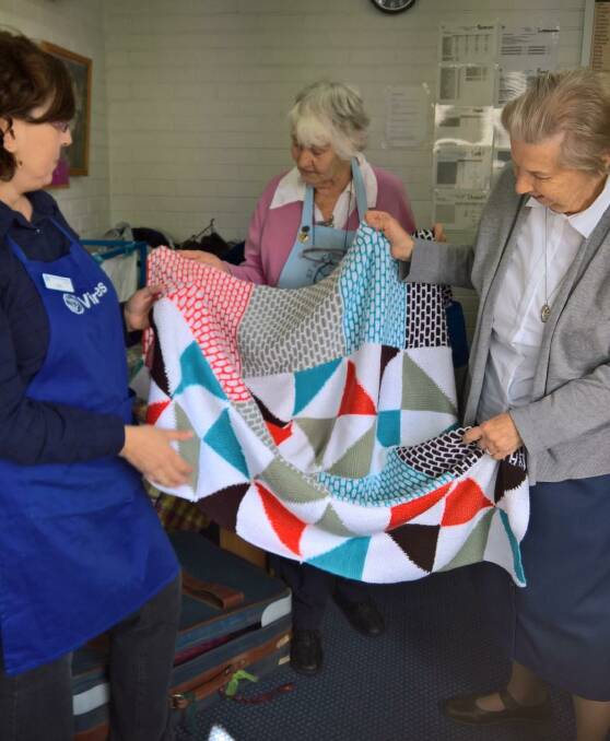 St Vincent de Paul Moss Vale volunteers admiring a donated blanket for the Warm Up Winter Appeal. Photo: supplied