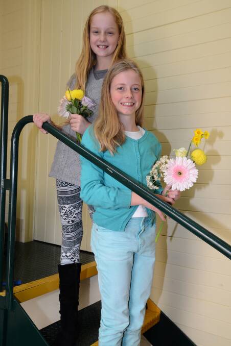 Freya Anthony (10) and Zoe Brain (10) collecting the flowers at one of Judith Warner's previous Biggest Morning Teas. Photo: file