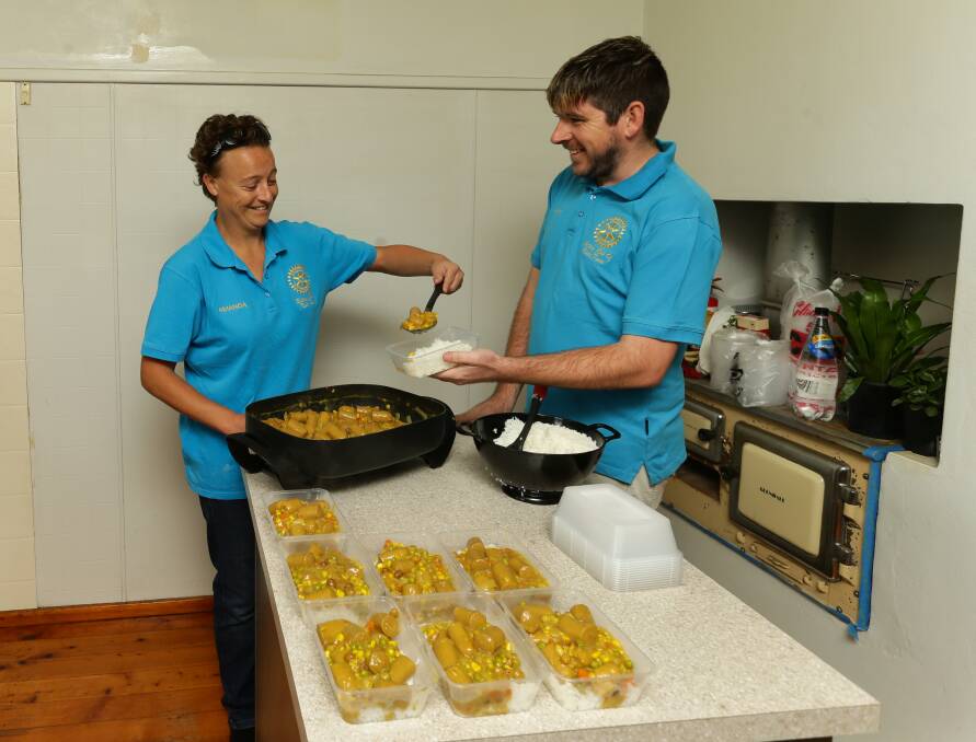 HELP IS AT HAND: Amanda Harris and Luke Hancock get another batch of home cooked meals ready for delivery. Picture Jonathan Carroll.