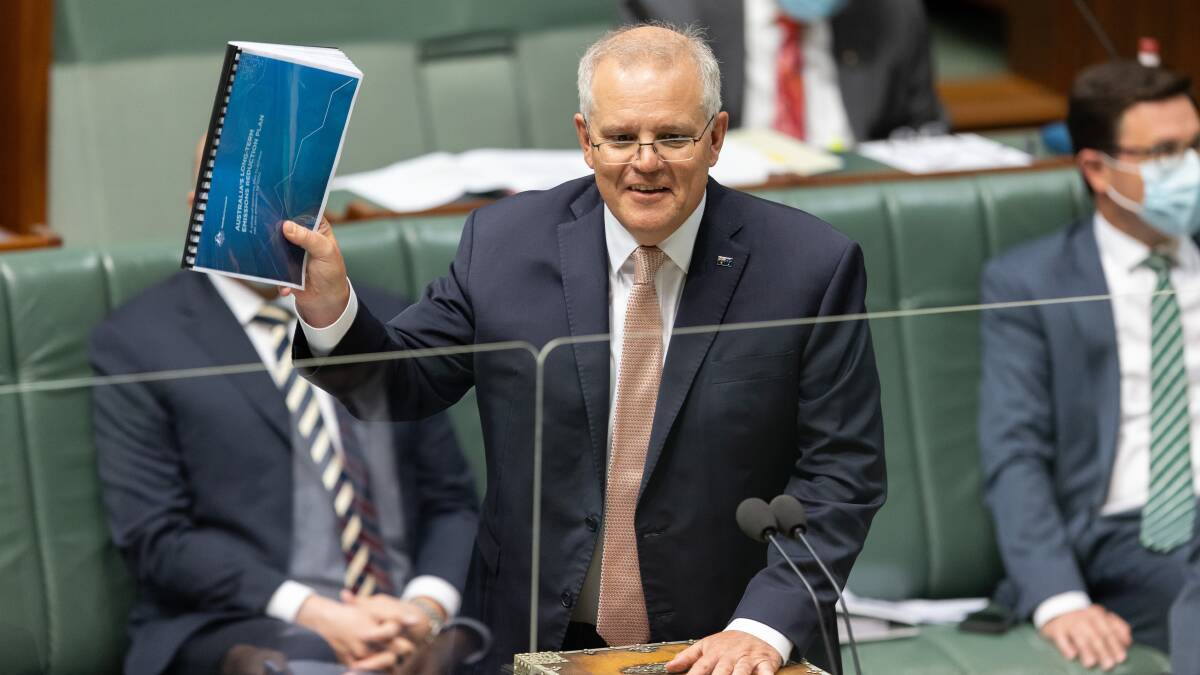 Prime Minister Scott Morrison brandishes a copy of the government's emissions plan during question time on October 26, 2021. Picture: Sitthixay Ditthavong