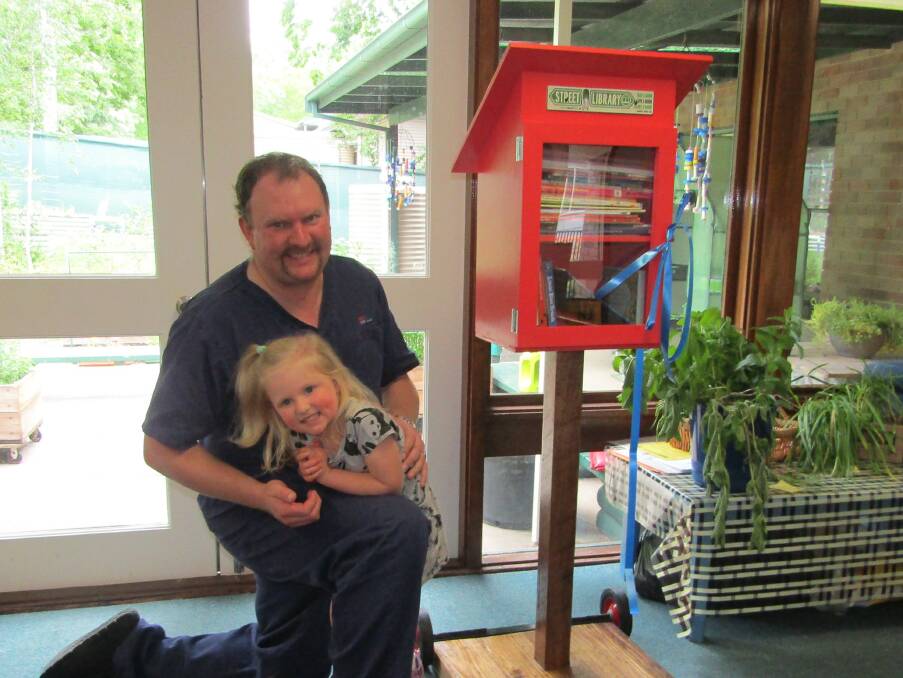 The street library was built by preschool parent Matthew Waldron who was given the honour of cutting the official ribbon at the opening with special help from his daughter Evelyn. Photos supplied.