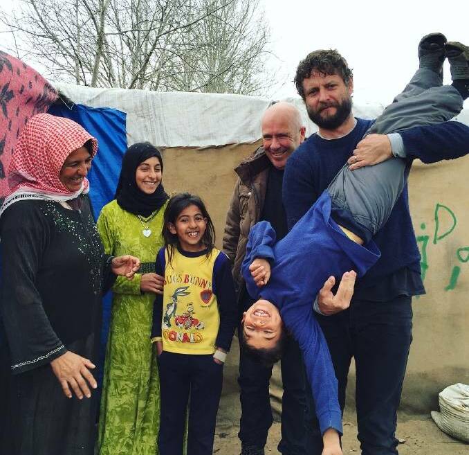 In just one month, donors have given $6 million to help support Afghan refugees through Mr Quilty's appeal (pictured right, with Richard Flanagan and refugees from Syria), just as 332,000 newly internally displaced people look down the barrel of a bitter winter. Photo: supplied