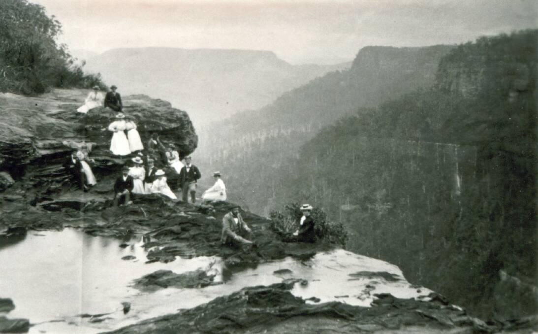 ON EDGE: Visitors at Fitzroy Falls dare to sit near the sheer drop, c1900. Photo: Bundanoon History Group.