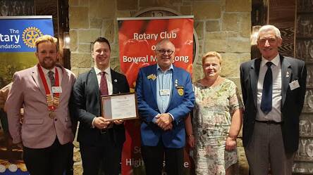 The charter for the Rotaract Club of Southern Highlands held by President William Koek with Rotaract representative Caleb Lees, Bowral HS Interact Coordinator Christine Sands and RC Bowral-Mittagong President Robert de Jongh at the Mittagong RSL Club.