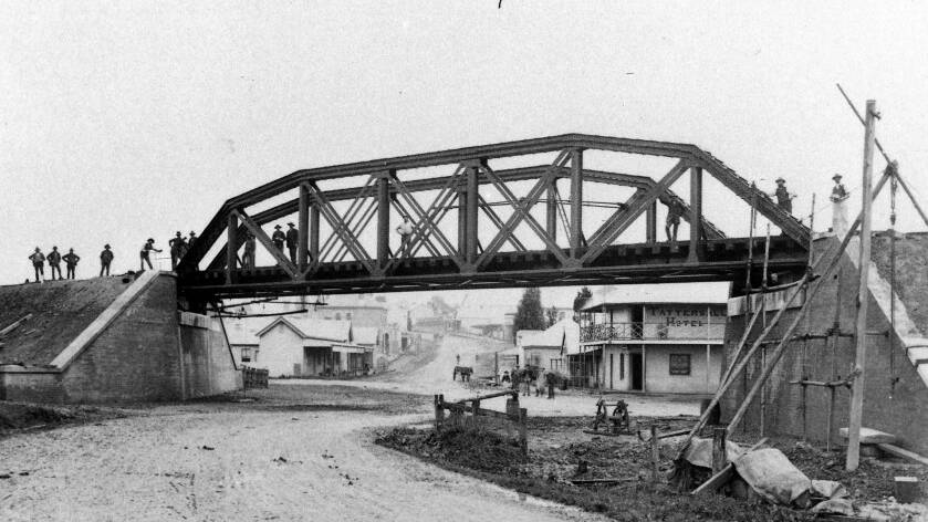 AT LACKEYS CORNER: Moss Vales second rail bridge going up, with Argyle St passing under and the Tattersall Hotel on right, c1885. Photo: BDH&FHS.