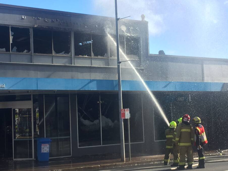 Firefighters late this morning were still attempting to cool hot spots in the roof of the ANZ Bank. Photo: Michelle Haines Thomas