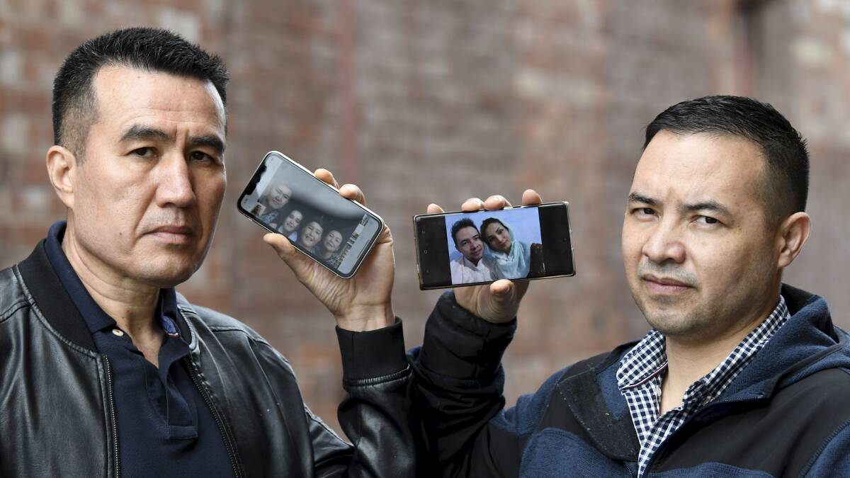 FEARS: Sadiq Taimori and Nadir Heidari with photos of their families who are in hiding in Afghanistan after the Taliban rose quickly to power. Picture: Lachlan Bence