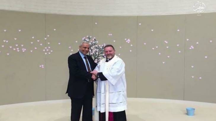 The Grand Mufti, Dr Abu Ibrahim Mohamed, is pictured in the Islamic State video shaking hands with inter-faith advocate and Anglican minister Father Rod Bowers. Photo: Supplied