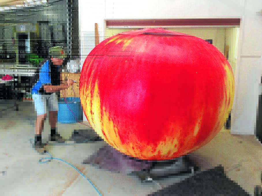 Alan Weston spray painting the Big Apple in his Tallong workshop.  
	Photo supplied by John Lombard