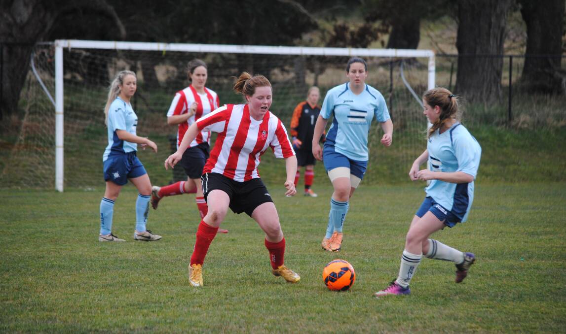 Moss Vale Red's Sharna Dunn (left) looks to take possession of the ball during a recent football game. Photo by Josh Bartlett
