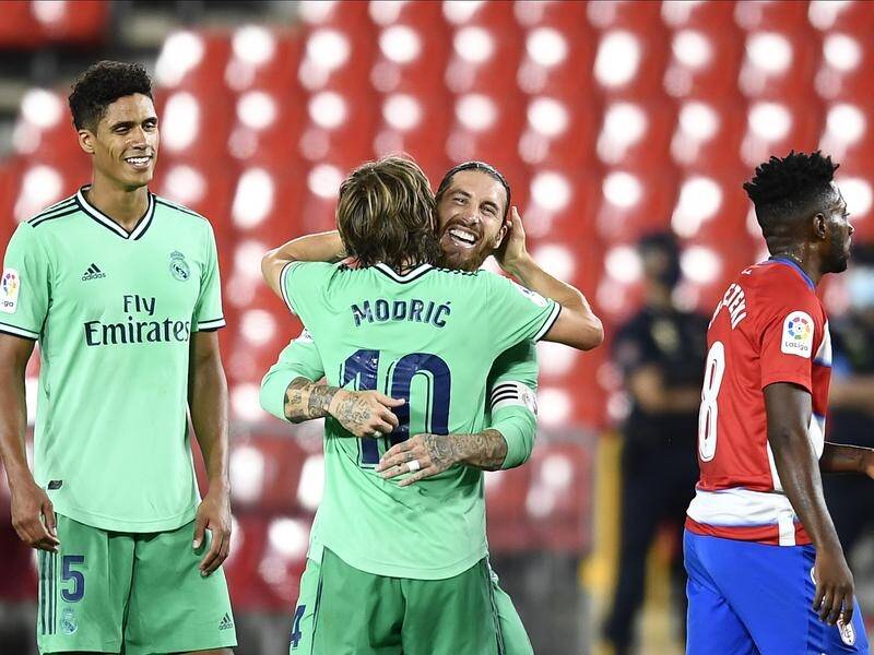 Real Madrid's Sergio Ramos hugs teammate Luka Modric as Raphael Varane looks on after their 2-1 win.