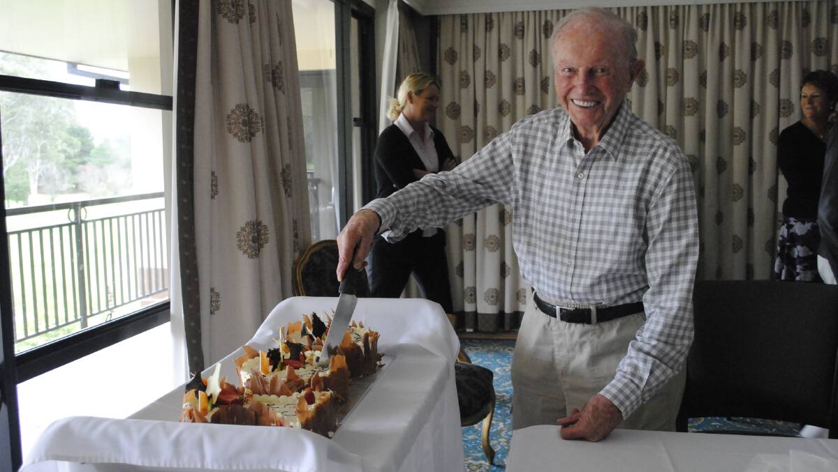 Gordon gave a big smile as he cut one of the three cakes. Photo by Megan Drapalski