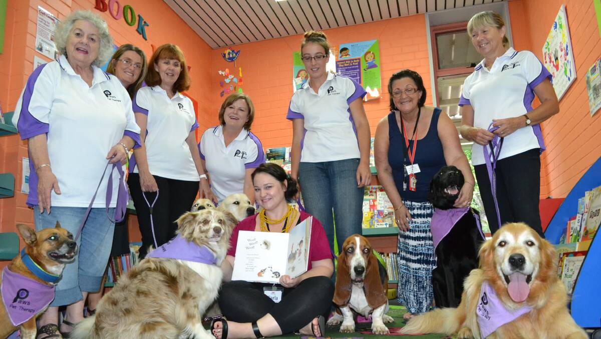 PRESS PAWS: Paws Pet Therapy members Catherine Horsley with Beau, Nicole Lonesborough from Nowra Library, Diane Bracher with Meg, Sharon Stewart with Rocky and Hudson, Erin Smith with Josephine, Marie Torbruegge from Nowra Library and Dawn Spicer with Bear and Joe with Nowra Library’s children’s and youth services library technician Carla De Casti get ready to trial the Paws ‘n’ Tales program designed to help children enjoy reading.