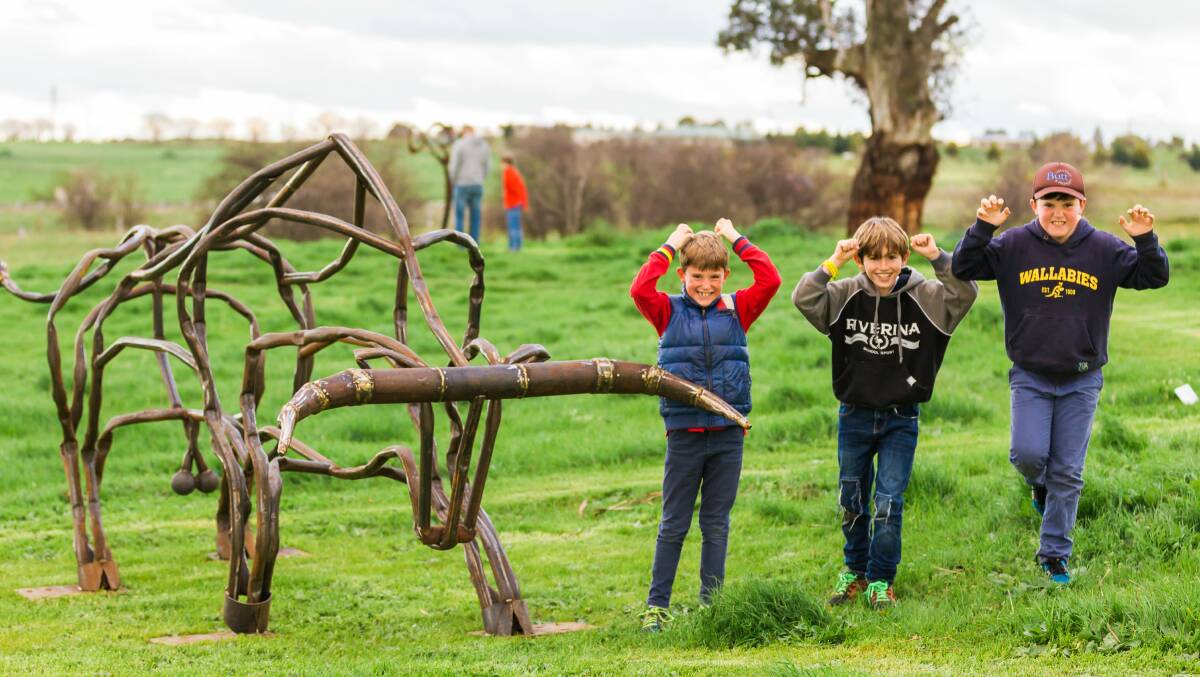 LOOK AT ME: Kids take on Tobias Bennett's steel bull 'Rampage', winner of Sculpture in the Paddock 2016.