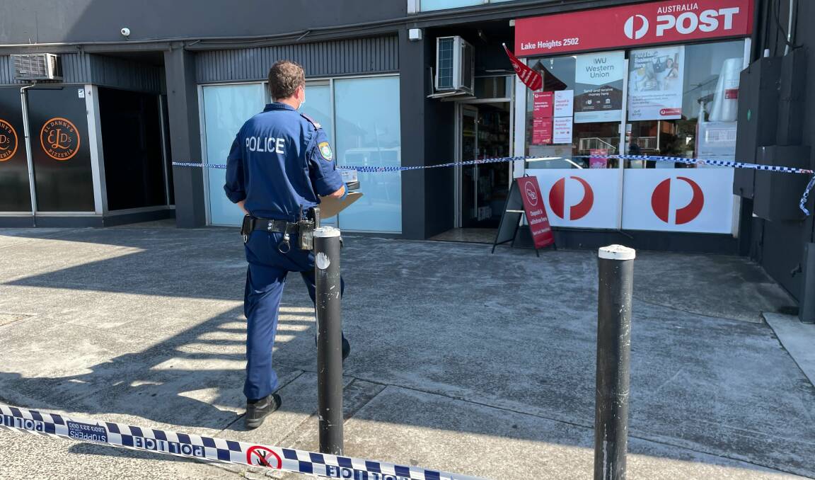 A crime scene forensic police officer conducting his investigation at the Australia Post branch in Lake Heights. Picture by Nadine Morton 