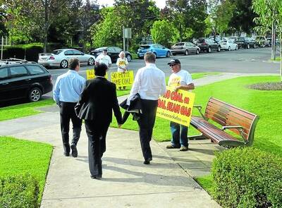 Protesters at Hume Coal's presentation to Wingecarribee Shire Council on Wednesday greet representatives of the mining company as they leave the building. 	Photo submitted