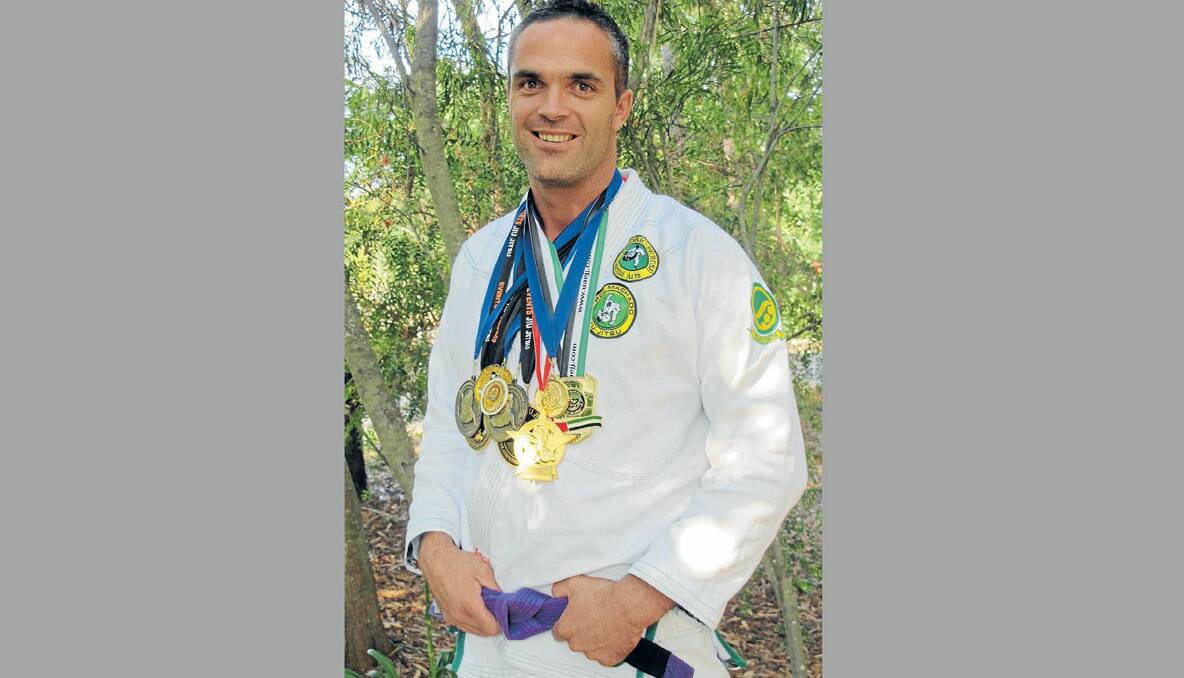 Tony Pycroft shows off the medals he won in 2012 as well as his new purple belt. Photo supplied 